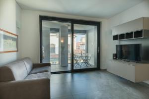 a living room with a couch and a television at Bergamo SottoSopra Gold in Bergamo