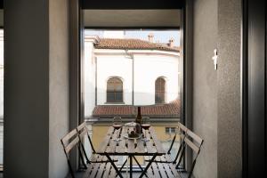 a table with chairs and a window with a building at Bergamo SottoSopra Gold in Bergamo