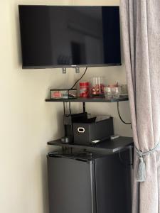 Ein Flachbildfernseher hängt an einer Wand neben einem Vorhang. in der Unterkunft Voogdtstraat 7 in Sluis
