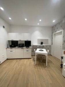 a kitchen with white cabinets and a white table at Cledo Mare Luxury Stay - Benessere in Pescara