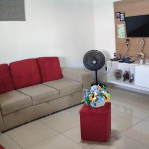 a living room with a couch and a table with flowers at Casa Bela in Itamaracá