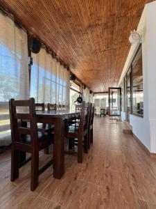 a dining room with a wooden ceiling and a table and chairs at Casa Valurile Marii in Sfântu Gheorghe