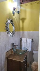 a bathroom with a glass sink and a mirror at Cozy Get Away in Portmore