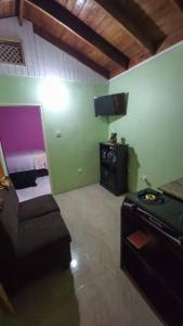 a room with a couch and a stove in it at Cozy Get Away in Portmore