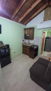 a kitchen with a stove and a couch in a room at Cozy Get Away in Portmore +4 photos
