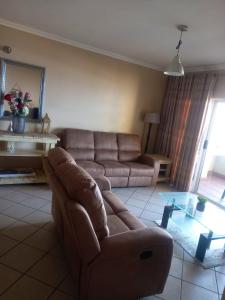 a living room with a couch and a glass table at Lescalier 513 Luxury sea facing unit in Amanzimtoti