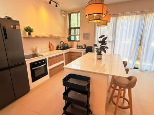 a kitchen with a refrigerator and a table with chairs at Sharing Pool Villa Sritanu in Ko Phangan