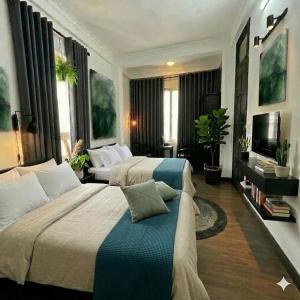 a hotel room with two beds and a television at Muse Riverside in Ninh Binh