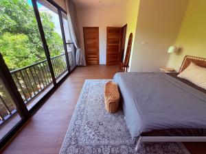 a bedroom with a bed and a balcony at Sharing Pool Villa Sritanu in Ko Phangan