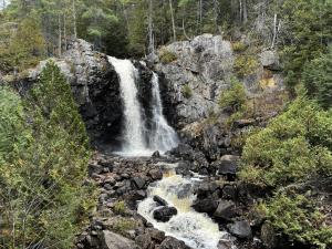 a waterfall on the side of a rocky mountain at Villa Forêsta Ski, Spa & Sauna in Saint Come +41 photos