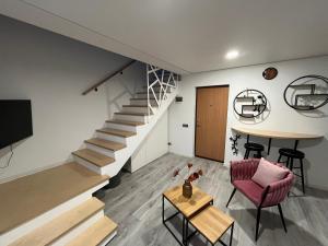 a living room with a staircase and a red chair at Apartments ,,Morena'' Melnragė in Melnragė