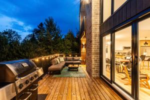 an outdoor patio with a couch and a grill at Villa Forêsta Ski, Spa & Sauna in Saint Come
