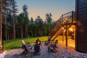 a patio with chairs and a grill and a staircase at Villa Forêsta Ski, Spa & Sauna in Saint Come