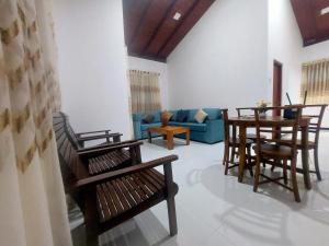 a living room with chairs and a table and a couch at Skyline Residence in Wadduwa