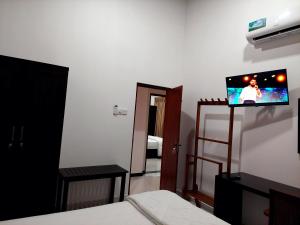a room with a tv on a wall with a bedroom at Skyline Residence in Wadduwa