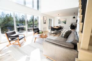 a living room with a couch and a table at Villa Forêsta Ski, Spa & Sauna in Saint Come