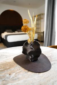 a black vase with flowers in it on a table at Valverda - Boutique Apartments in Grödig +45 photos