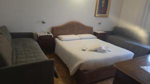 a living room with a bed and a couch at ROOMS CA' TUNIN- ideale per il Trenino Rosso- a pochi minuti a piedi dalla stazione in Tirano
