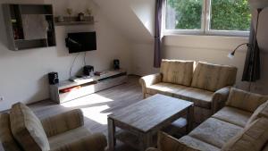 a living room with two couches and a tv at Ferienwohnung Mabo in Kempen