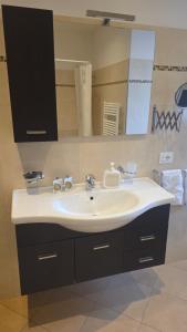 a bathroom with a sink and a large mirror at ROOMS CA' TUNIN- ideale per il Trenino Rosso- a pochi minuti a piedi dalla stazione in Tirano