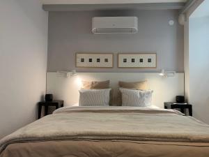 a bedroom with a large bed with white walls at Cozy Old Town Interlude Apartment in Dubrovnik