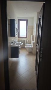 a bathroom with two sinks and a toilet and a window at ROOMS CA' TUNIN- ideale per il Trenino Rosso- a pochi minuti a piedi dalla stazione in Tirano