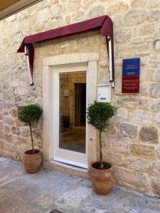 two potted plants sitting in front of a building at Cozy Old Town Interlude Apartment in Dubrovnik