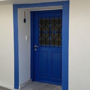 a blue door with a wrought iron window at Oikos Filon in Palaiókastron