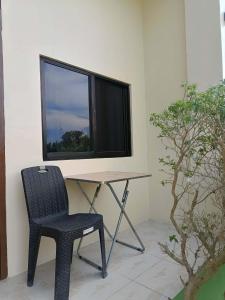 a table and a chair in a room with a window at Lake Lovers Stay Hostel in Badian