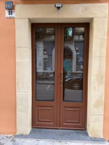 a wooden door in a building with glass windows at La Maison Du Theatre in Catania +10 photos