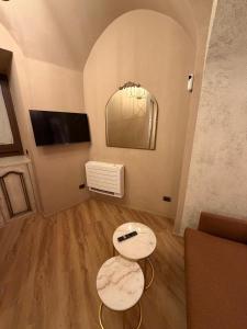 a living room with two tables and a mirror at La Maison Du Theatre in Catania