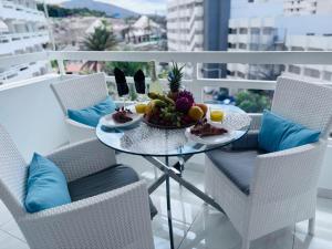 a table with a bowl of fruit on a balcony at Blue Ocean Costa Adeje 502 in Playa de las Americas