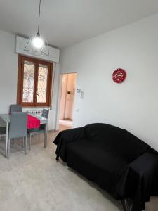 a bedroom with a black bed and a dining table at Bilocale Le Rose in Vada +12 photos
