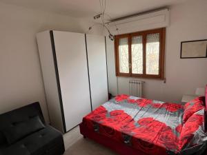 a bedroom with a bed and a black chair at Bilocale Le Rose in Vada