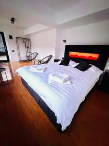 a bedroom with a large bed with white sheets at Twin Cabins Azuga in Azuga