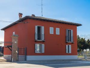 a red house with a black gate at Moderno Bilocale Con Parcheggio Privato in Piacenza