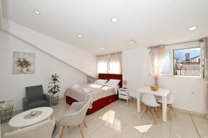a room with a bed and a table and chairs at Old town central in Kotor