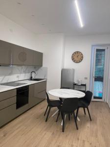 a kitchen with a table and chairs and a clock on the wall at Credo Mare Luxury Stay - Comfort in Pescara +25 photos