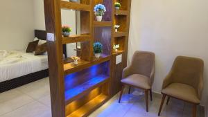 a room with two chairs and a room with a bed at Ourea's Rest in Thekkady
