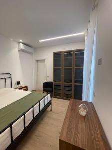 a bedroom with a bed and a wooden table at Credo Mare Luxury Stay - Comfort in Pescara