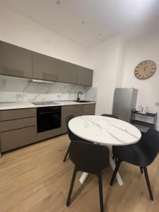 a kitchen with a table and chairs and a clock at Credo Mare Luxury Stay - Comfort in Pescara