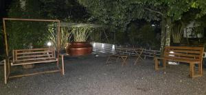 a group of chairs and a table and a large pot at Ourea's Rest in Thekkady +2 photos