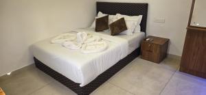 a bedroom with a bed with white towels on it at Ourea's Rest in Thekkady