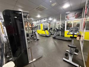 a gym with several treadmills and cardio machines at Muscat Beach Hostel in Muscat
