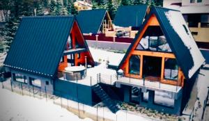 a model of a house with snow on the roofs at Twin Cabins Azuga in Azuga +5 photos