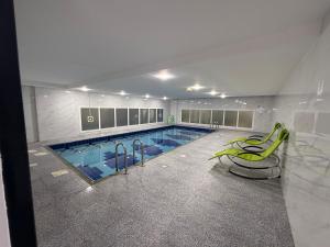 a large swimming pool in a building at Muscat Beach Hostel in Muscat