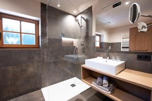 a bathroom with a sink and a shower and a mirror at Residence Burghof in Siusi +75 photos