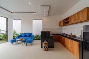 a kitchen with blue chairs and a table in a room at Cahya Restu Ubud Villa in Ubud