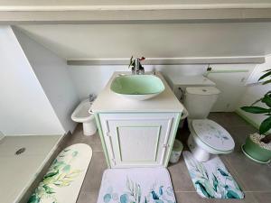 a bathroom with a sink and a toilet at La porte bleue in Baie-Mahault