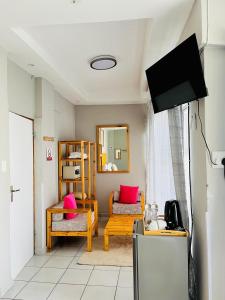 a living room with pink pillows and a tv at Thabeng Hotel & Restaurant in Maseru